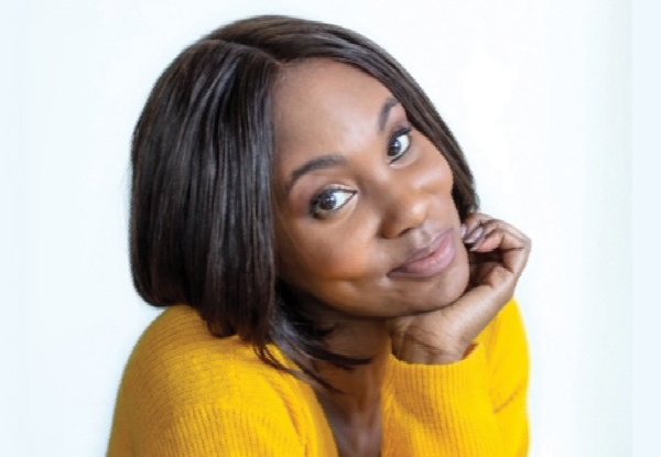 Woman in yellow sweater smiling at the camera.