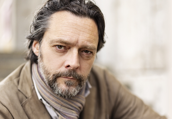 Middle-aged man with a beard looking intently at the camera.