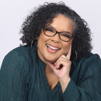 Portrait of a joyful woman with glasses wearing a green blouse.