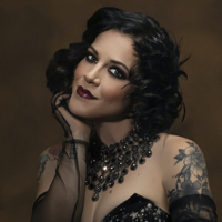 Portrait of an elegant woman with vintage style makeup and tattoos.
