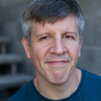 Portrait of a smiling middle-aged man with gray hair.