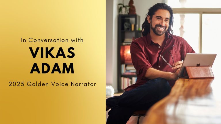 Man smiling at camera, using laptop at home with text "In Conversation with VIKAS ADAM, 2025 Golden Voice Narrator."